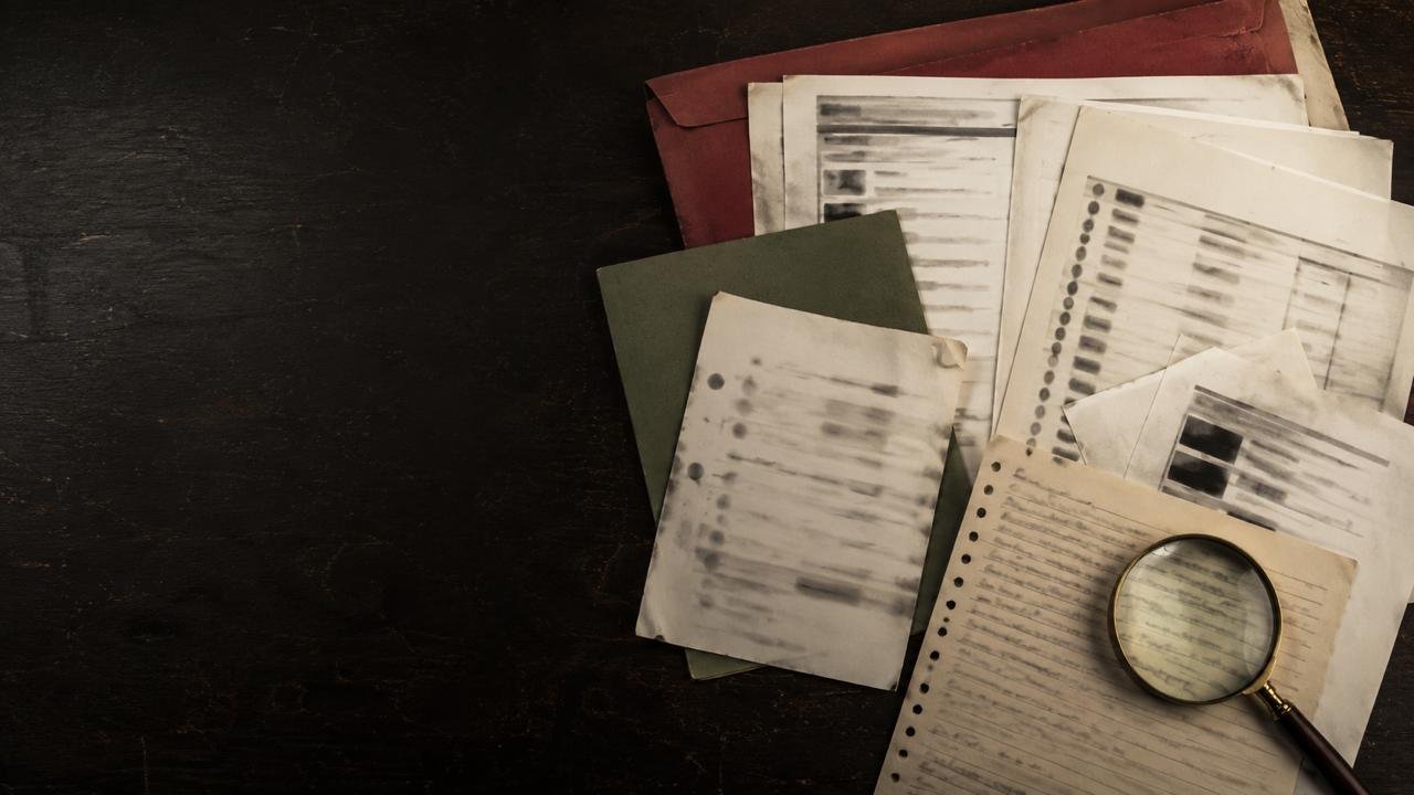 Documentos e registros organizados sobre uma mesa para análise de prova em investigação de fraude, sem pessoas identificáveis.
